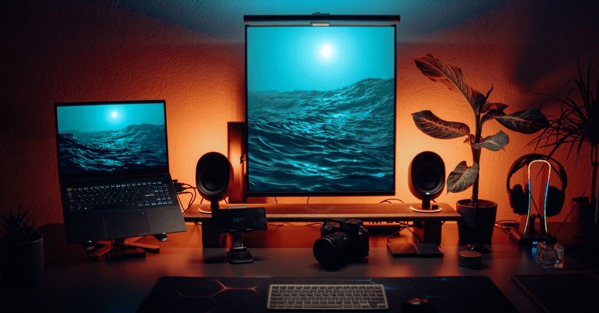Stylish office setup featuring dual monitors, tech gadgets, and ambient lighting.