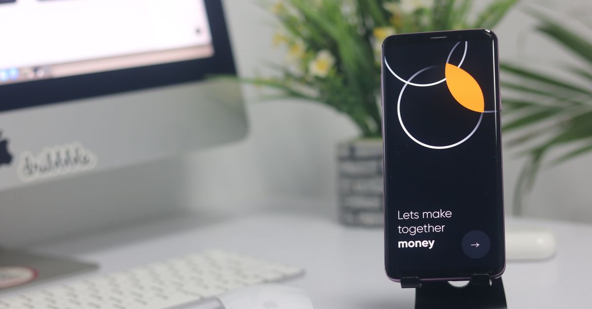 A modern workspace with a smartphone displaying a screen and a computer setup, ideal for business and technology themes.